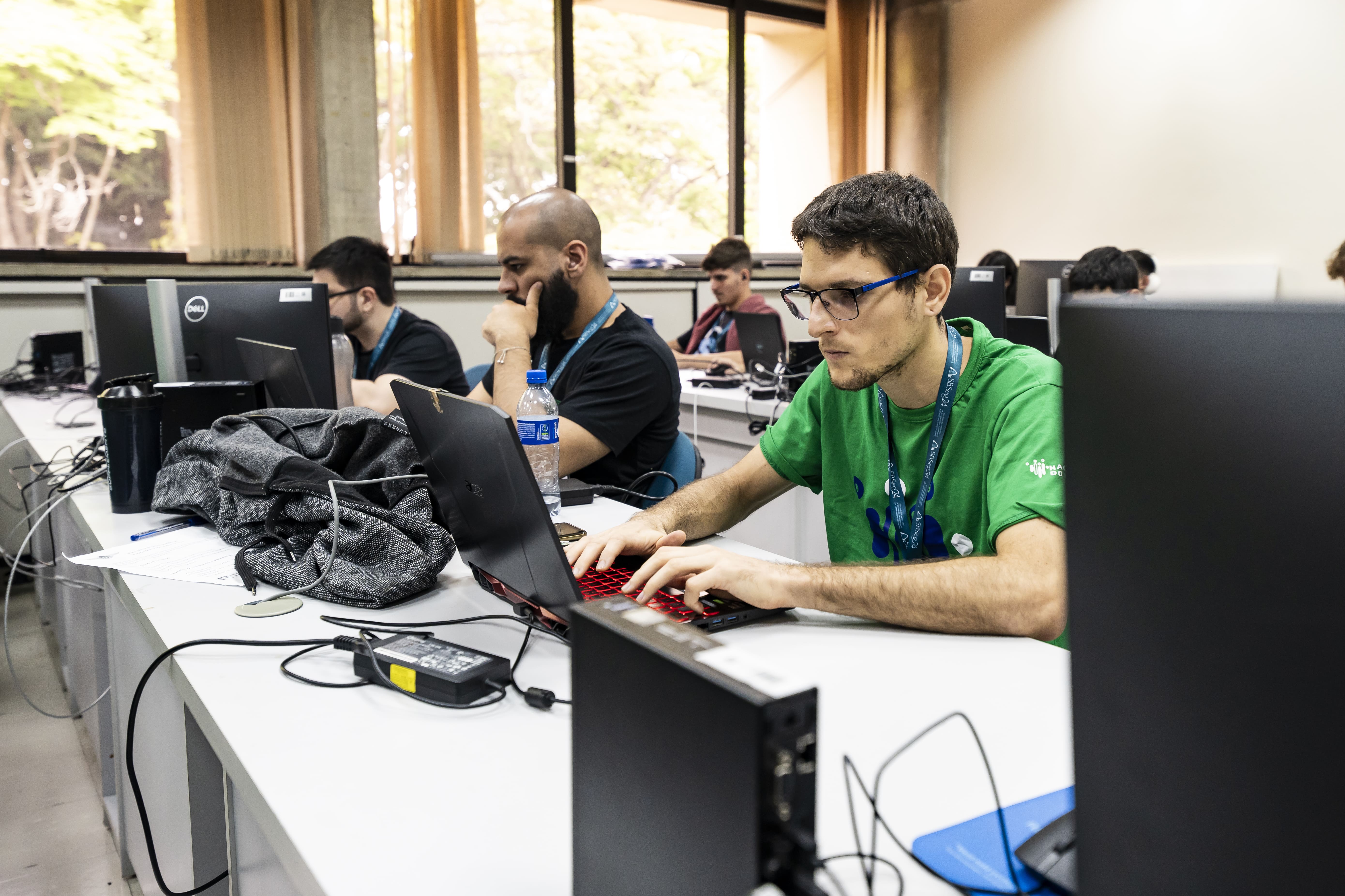 Três meninos brancos olhando concentrados para o computador.